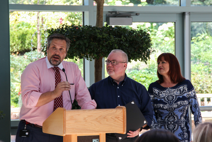 Jeff Herring, from left, speaks after presenting Burrows a Staff Excellence Award while Lovett watches.