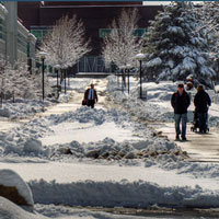 People walk on a snowy University of Utah campus.