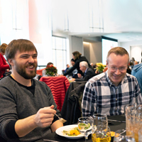 Mitch West, from left, and Doug Kenner laugh while eating lunch during the 2019 UIT holiday luncheon and prize drawing.